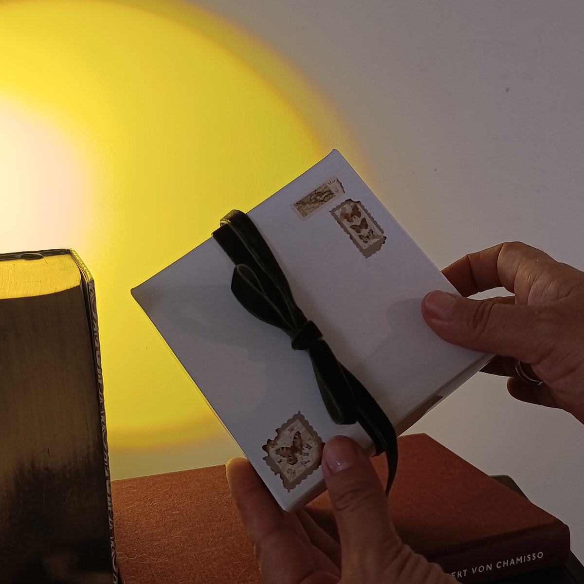 empaque de vela aromática, caja blanca con postales y listón verde aterciopelado